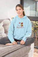 Happy Howlidays Unisex Heavy Blend Hoodie, blue, worn by a person sitting comfortably indoors.