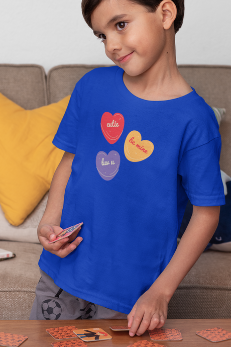 Candy Hearts Unisex Kid's Softstyle T-Shirt on child model, featuring heart graphics with phrases.